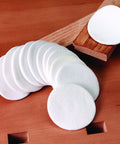 Top Shelf 12 Pack Cotton Finishing Pads With Super Fine Grit For Smooth Wood And Plastic Projects, 3 inches wide pads on a wooden surface.