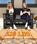Two women sitting on an Outdoor Two Person Glider Bench For Backyard With Armrests HDPE Weather Resistant Double Swing Glider Rocking Chair Loveseat Slatted Seat And Back Perfect Patio Garden Porch Seating Black on patio