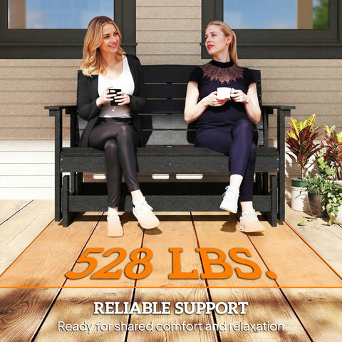 Two women sitting on an Outdoor Two Person Glider Bench For Backyard With Armrests HDPE Weather Resistant Double Swing Glider Rocking Chair Loveseat Slatted Seat And Back Perfect Patio Garden Porch Seating Black on patio