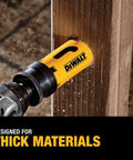 DEWALT bi-metal hole saw attached to a drill cutting thick wood; yellow tool with DEWALT logo.