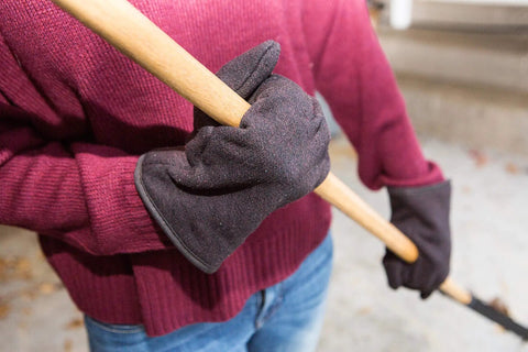 Person wearing Brown Jersey Winter Work Gloves with Red Fleece Lining holding a tool