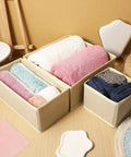 6 Piece Underwear Drawer Organizer Set Features Fold Flat Storage Bins with colorful rolled towels in beige bins on a wooden table.