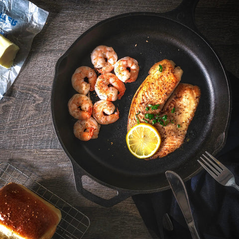 12 Inch Cast Iron Skillet With Lid Pre Seasoned Chef Pan For Indoor And Outdoor Cooking Even Heat Distribution Delivers Gourmet Seared Steaks Crispy Edges And Caramelized Veggies Campfire Ready Durable Safe Grill Cookware For Everyday Use featuring shrimp and fish with lemon