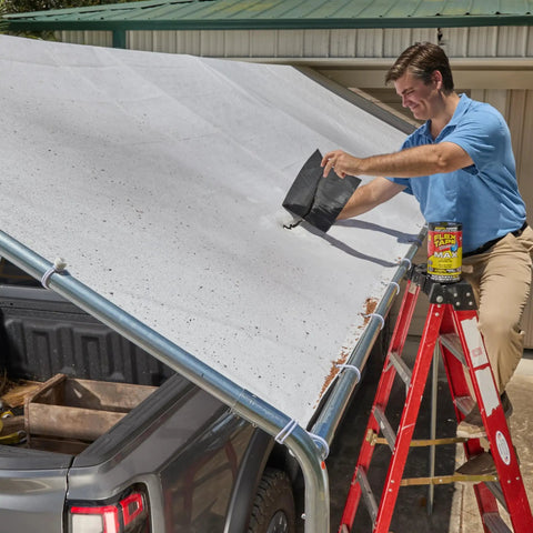 Person applying thick rubberized waterproof tape that patches leaks, seals and repairs virtually anything on a roof.
