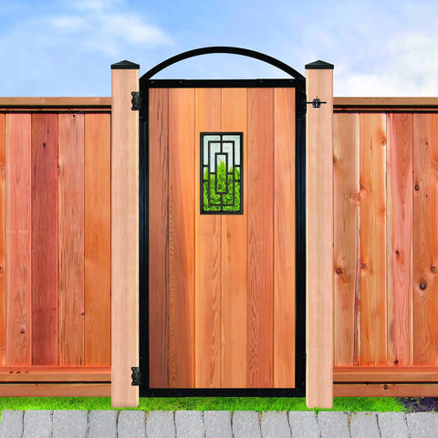 Wooden gate with wrought iron accents set in a cedar fence with decorative post caps, outdoors in a garden setting.