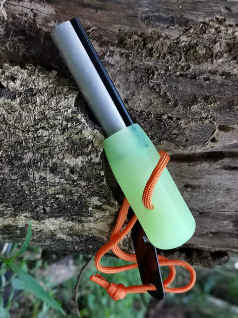 Grab And Go Emergency Fire Starter Kit With Magnesium And Ferro Rods, luminous green handle and orange paracord on wood