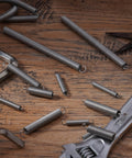 Six stainless steel extension springs with hook ends (2-inch) on a wooden workbench.