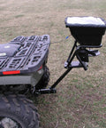 12V Grass Seed And Fertilizer Spreader With 80 Pound Capacity mounted on ATV, showing hitch mount receiver and rain protector.