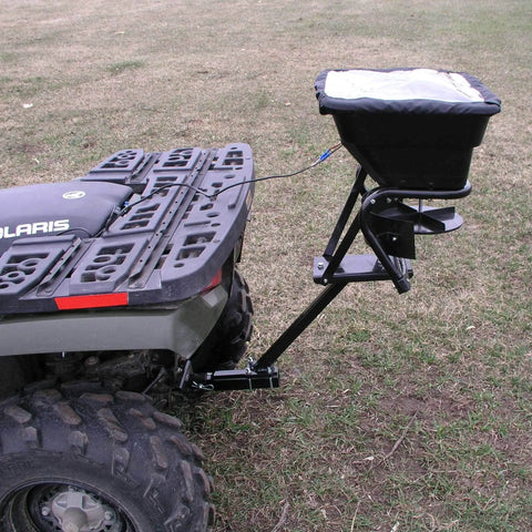 12V Grass Seed And Fertilizer Spreader With 80 Pound Capacity mounted on ATV, showing hitch mount receiver and rain protector.
