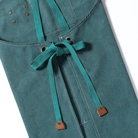 Close-up of Heavy Duty Cross Back Cotton Canvas Apron With Extra Large Pockets For Home Cooks And Pros Pro Grade 31 By 27 Inches 16 Ounce Durable Fabric Wide Chest To Knee Coverage Dark Green showing tie straps.