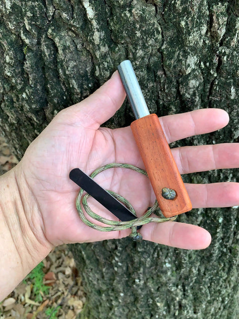 Hand holding European Ferro Rod Fire Starter with Magnesium for Camping, 5-inch length, hardwood handle, paracord attached.
