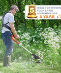 Person using a trimmer in a garden with a sign stating 'Ideal for mowing your lawn, deterioration cycle: 5 years'.