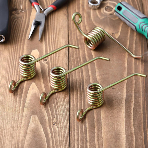 4 Pack Universal Power Rake Replacement Springs For Maxpower 330105 Dethatcher 16 Inch Mower Blade And Arnold 16 Inch Dethatching Replacement Blade With Easy Install Fits Most Lawn Mowers. Four metal coil springs on a wooden surface with tools.