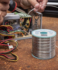 Sn60Pb40 Solder Wire With 2.2% Flux, 0.3 mm Diameter, 100 g Spool for precision hand soldering with smooth wetting, shown in use.