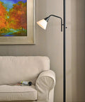 Rush Floor Lamp In Oil Rubbed Bronze 72 Inch Tall Torchiere With White Glass Shade next to beige sofa in living room