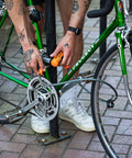 Person securing bike with Mini U Lock With 4 Ft Security Cable, 7mm Hardened Steel Shackle, Double Deadbolt Locking, city commuter lock