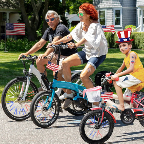 Family riding bikes with Reflective Bike Spoke Covers Set of 72 Pieces Red White Blue Wheel Skins for 4th of July.