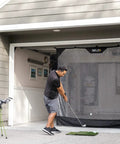 Man practicing golf with 7 Foot Wide Baseball Softball And Golf Hanging Practice Net For Home Hitting Pitching And Driving Practice, Rolls Up Easily For Storage, Garage Door Mount, Durable Fiberglass Bottom Pole And Ball Catch in garage