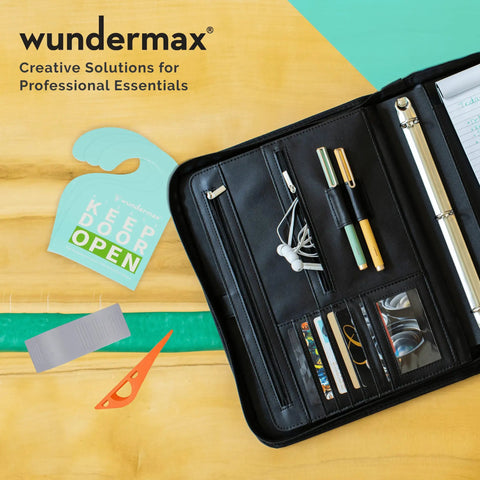 Open organizer folder with pens, cards, and stationery on a table next to a green door hanger and orange cutter, branded 'wundermax'