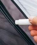 Hand applying Zipper Lubricant Wax For Tents Drysuits Soft Coolers And More Includes 2 Sticks to a tent zipper