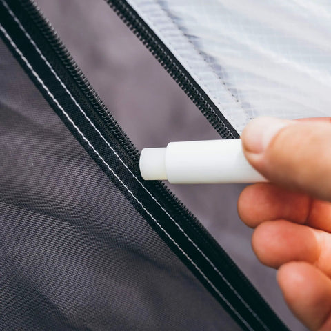 Hand applying Zipper Lubricant Wax For Tents Drysuits Soft Coolers And More Includes 2 Sticks to a tent zipper