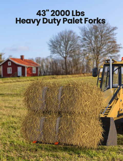 Beefy 43 Inch 2000 Lbs Heavy Duty Pallet Forks lifting hay bales on loader bucket skid steer tractor in field.