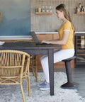 Woman sitting on SitWell Wobble Stool With Adjustable Height For Active Seating In Classrooms And Libraries, Durable Black, at desk.