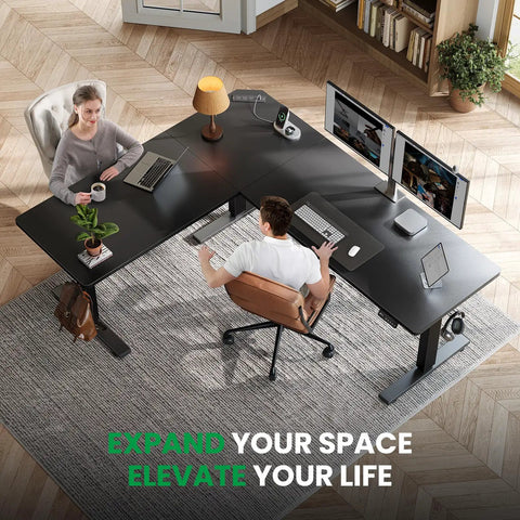 Two people working on L Shaped Standing Desk With 63 By 55 Inch Corner Desk And Built In Charging Station For Home Office And Gaming Setup Memory Controller And Easy Sit Stand Adjustments