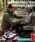 Two red first aid kits with organized compartments on a forest hiking trail.