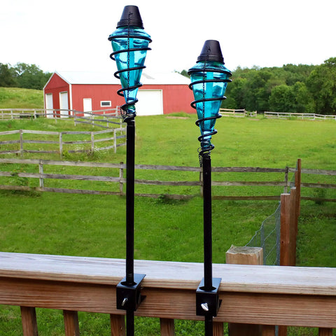 Two Pack Glass Patio Torch Set, tall outdoor torches with adjustable height up to 66 inches, blue glass vessels with metal casings on deck