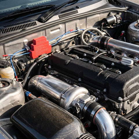 Detailed view of an engine bay showing metal tubing and a red component, highlighting the Auto Aerosol Fire Extinguishers With Dual Nozzles For Slick Hands Off Flame Control And Bulletproof Emergency Cover That Truly Is A No Sweat Go To Gear Setup For Your Car Rv Or Office.