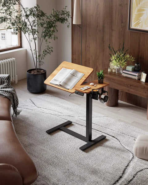 Yihayo Electric Height Adjustable Overbed Table W/ Wheels, 24x16 Inch mobile nursing stand desk with opened book and coffee holder.