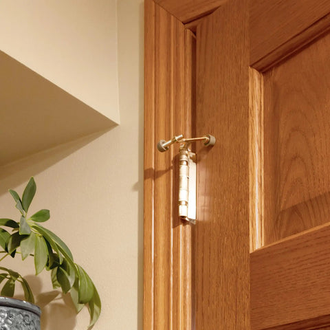 Five Pack Hinge Pin Door Stops With Rubber Tips And Wall Protectors installed on wooden door, satin nickel adjustable style.
