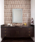 Modern bathroom vanity with antique brass cabinet knob handles, featuring geometric wall tiles and a rectangular mirror.