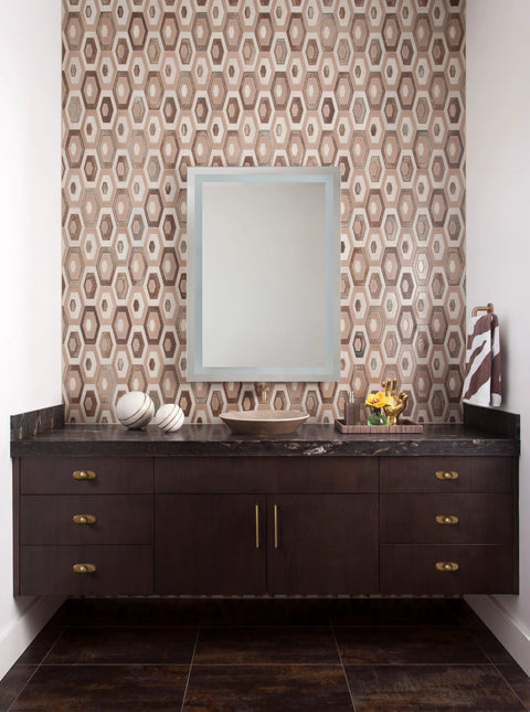 Modern bathroom vanity with antique brass cabinet knob handles, featuring geometric wall tiles and a rectangular mirror.