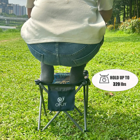 Person sitting on Ultralight Portable Folding Camping Stool With Carry Bag, compact green chair in park, holds 320 lbs.