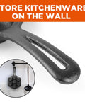 Close-up of Seven Section Cast Iron Danish Aebleskiver Pan handle, shown hanging on a kitchen wall with ladle.