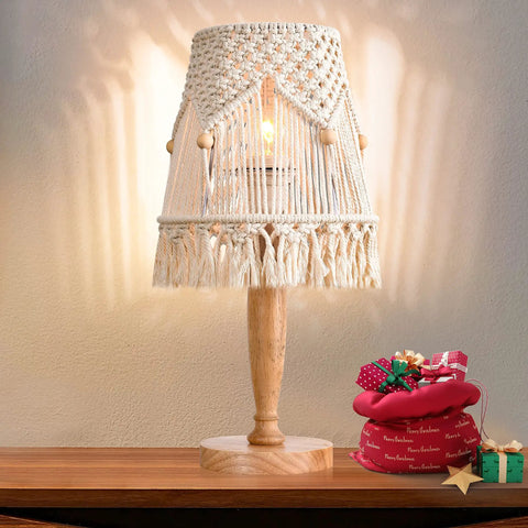 Boho Cotton Rope Bedside Lamp With Handmade Bohemian Shade, on wooden base, decorated with gifts, emitting a warm glow.