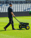 Person using Spyker P70-12010 Commercial Drop Spreader With 120 Lb Hopper, 36 Inch Spread Width, Powder Coated Steel Frame on lawn