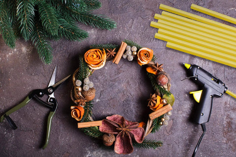 Crafting scene with glue gun, decorative wreath, and Woodworking Glue Sticks 10 Inch Long Diameter Eleven Millimeter Multi Temperature