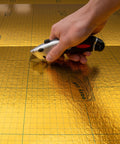Premium Flooring Underlayment Roll 100 Sq Ft 2Mm Thick with PreTaped Sides being cut with a utility knife.