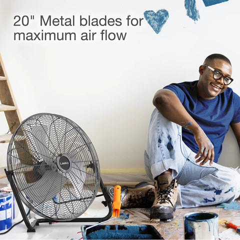 20 Inch High Velocity Wall Mount Fan With Pivoting Head next to artist with paint, showcasing its durable metal blades and easy airflow adjustment.