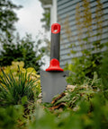 Heavy Duty Garden Trowel With Serrated Blade For Digging And Root Cutting Carbon Steel Hand Tool with red handle in soil