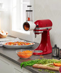 Fresh Prep Slicer Shredder Stand Mixer Attachment in use, slicing carrots with three blades, fits most mixers, durable stainless steel
