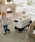 Child pulling 125 Qt Gray Party Bar Wheeled Cooler with Ultratherm Insulation Removable Lid That Converts To Open Air Beverage Tub