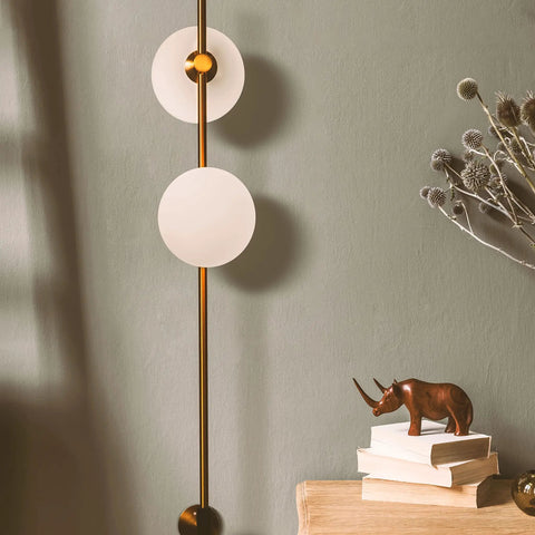 Equinox LED Wall Sconce Indoor Plug In Light For Bedroom And Bathroom With Glass Globe Shades Industrial Wall Mounted Fixture And On Off Switch Gold Finish Perfect For A Modern Home Vibe, showing gold sconce with frosted globes on green wall