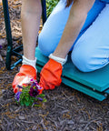 A person using a Garden Kneeler And Wide Seat That Flips Into A Comfy Sit Down Stool for pain-free weeding and planting on the go.