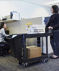 Top Tier Heavy Duty Two Shelf Utility Cart With Durable Structural Foam Lipped Trays And Smooth Glide Handles 500 Lb Capacity in an office setting.