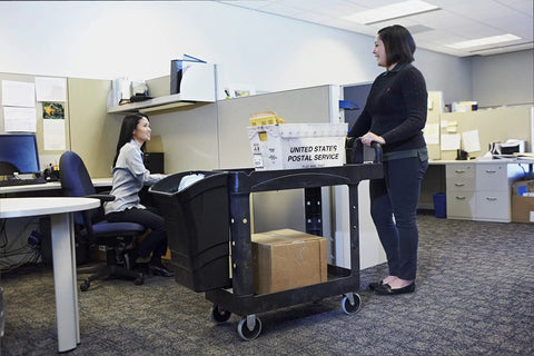 Top Tier Heavy Duty Two Shelf Utility Cart With Durable Structural Foam Lipped Trays And Smooth Glide Handles 500 Lb Capacity in an office setting.