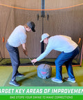 Golfers using Golf Swing Impact Bag Trainer to Fix Slices and Hooks in indoor practice setting with net setup.